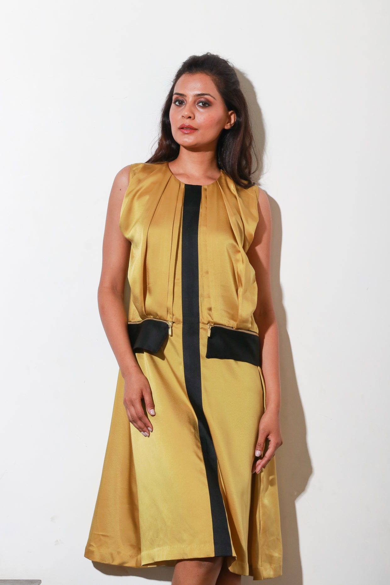 Mustard satin dress with pleats and paneled feature with black satin panel, and side zipper.
