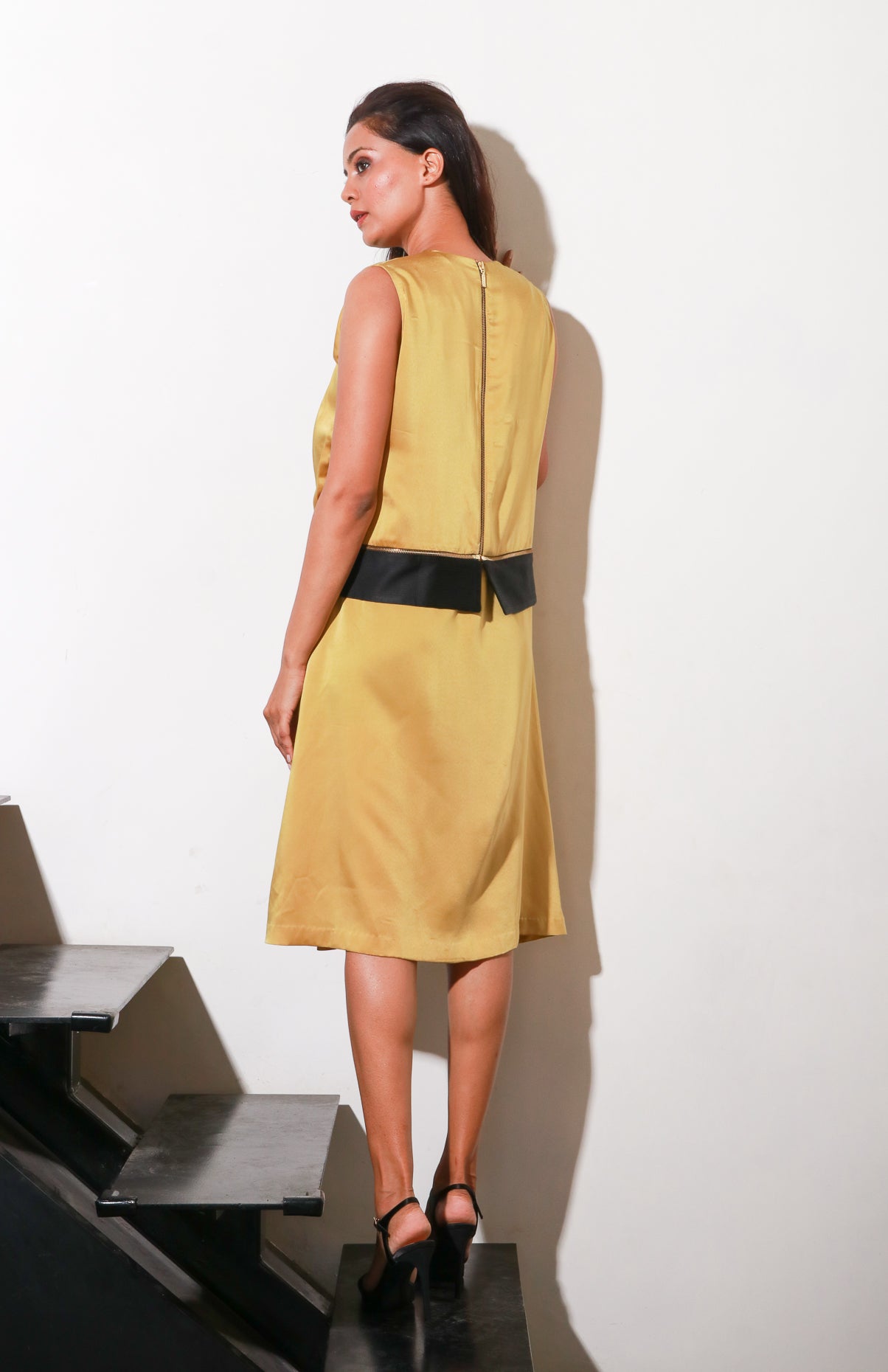 Mustard satin dress with pleats and paneled feature with black satin panel, and side zipper.