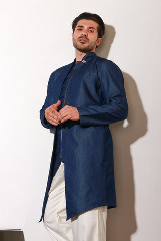 Denim zippered waist coat with self detailing and attached jacket paired with narrow off white pants.