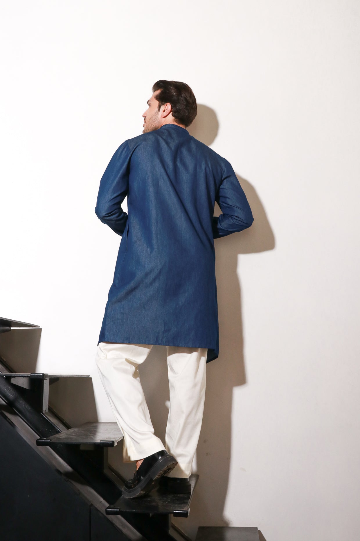 Denim zippered waist coat with self detailing and attached jacket paired with narrow off white pants.