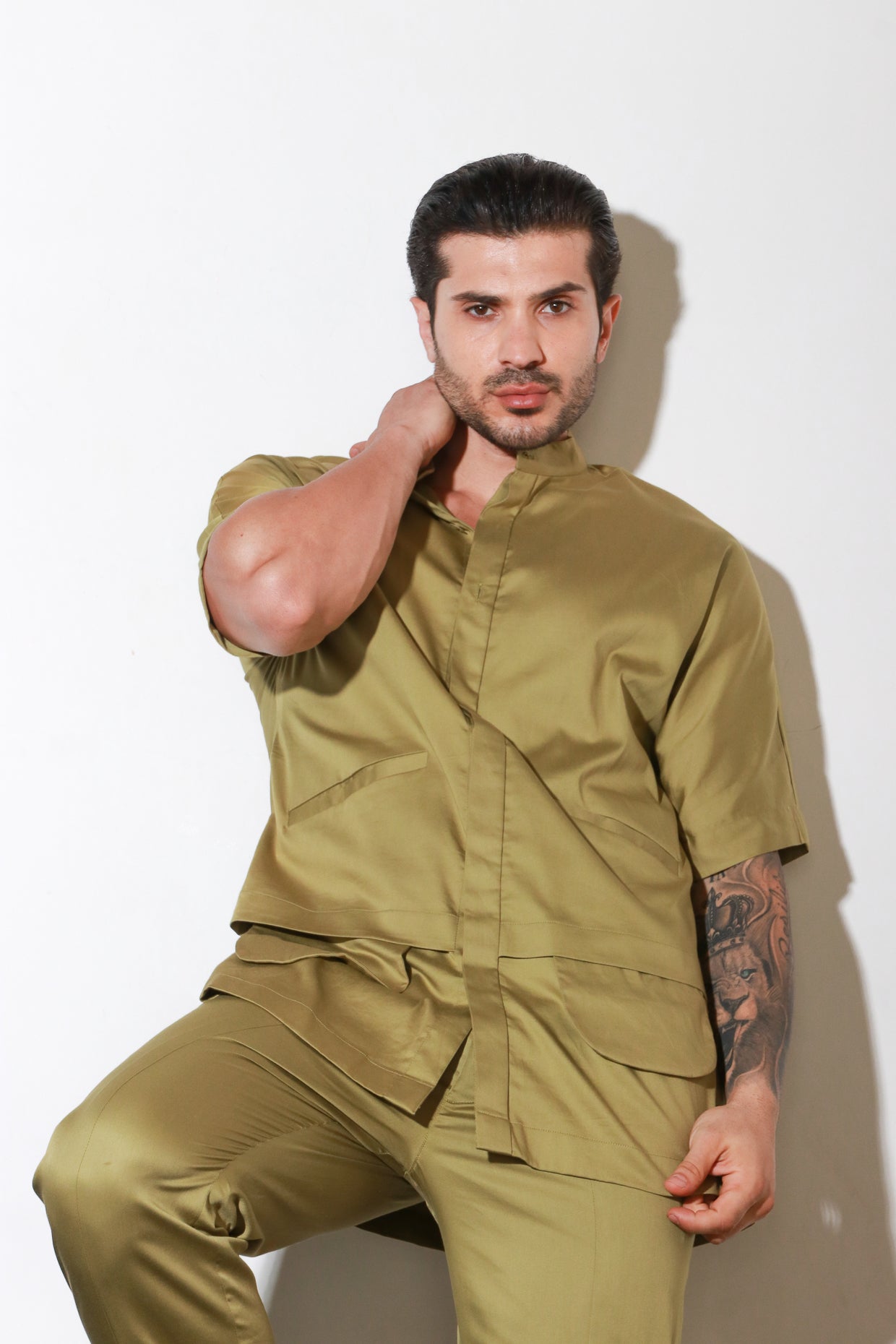 Green double layered shirt with pocket and flap feature paired with narrow pants with bottom zipper detailing.
