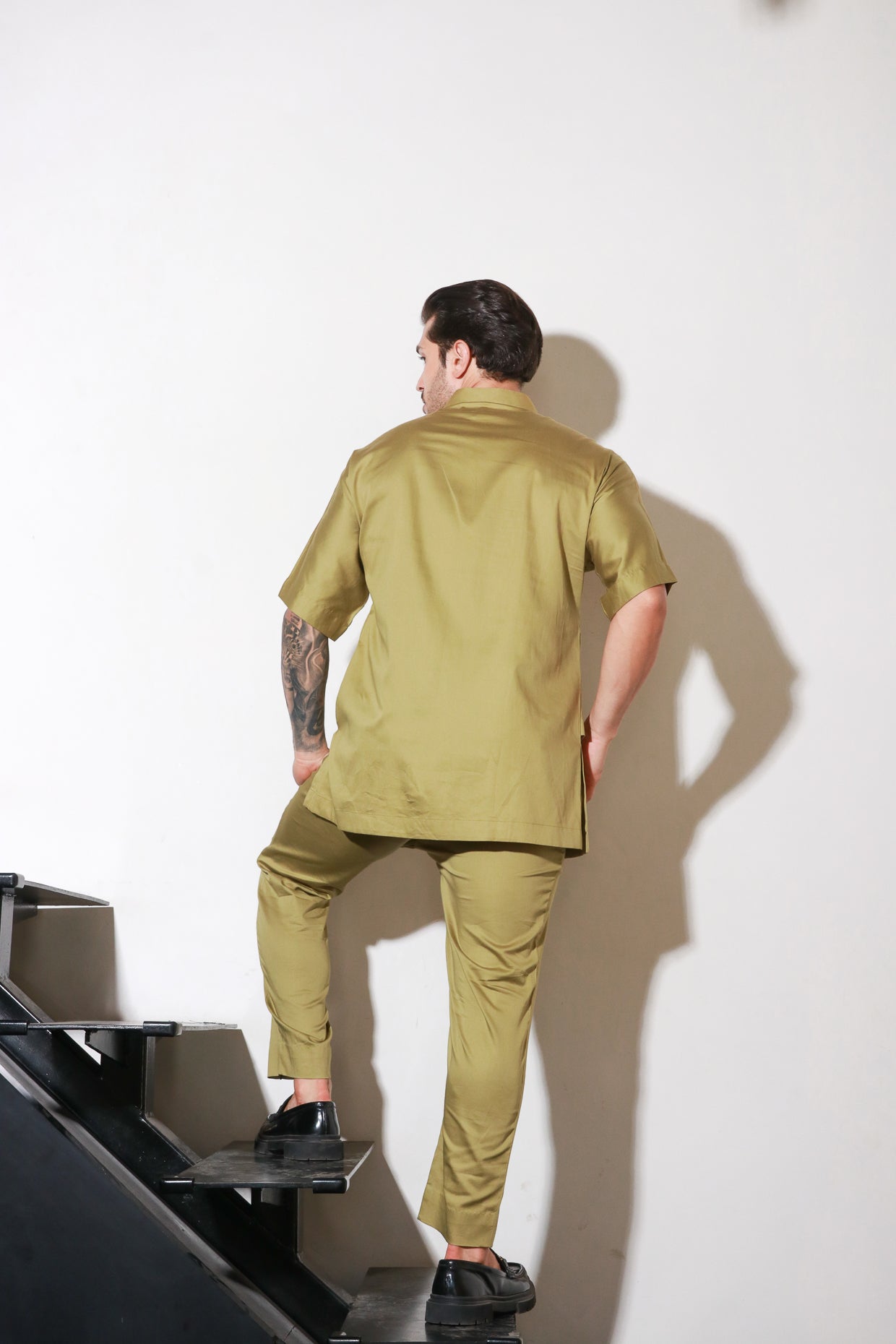 Green double layered shirt with pocket and flap feature paired with narrow pants with bottom zipper detailing.