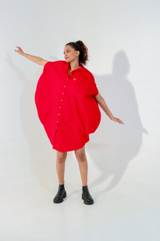 Red circle dress features one pocket & a golden eyelet.