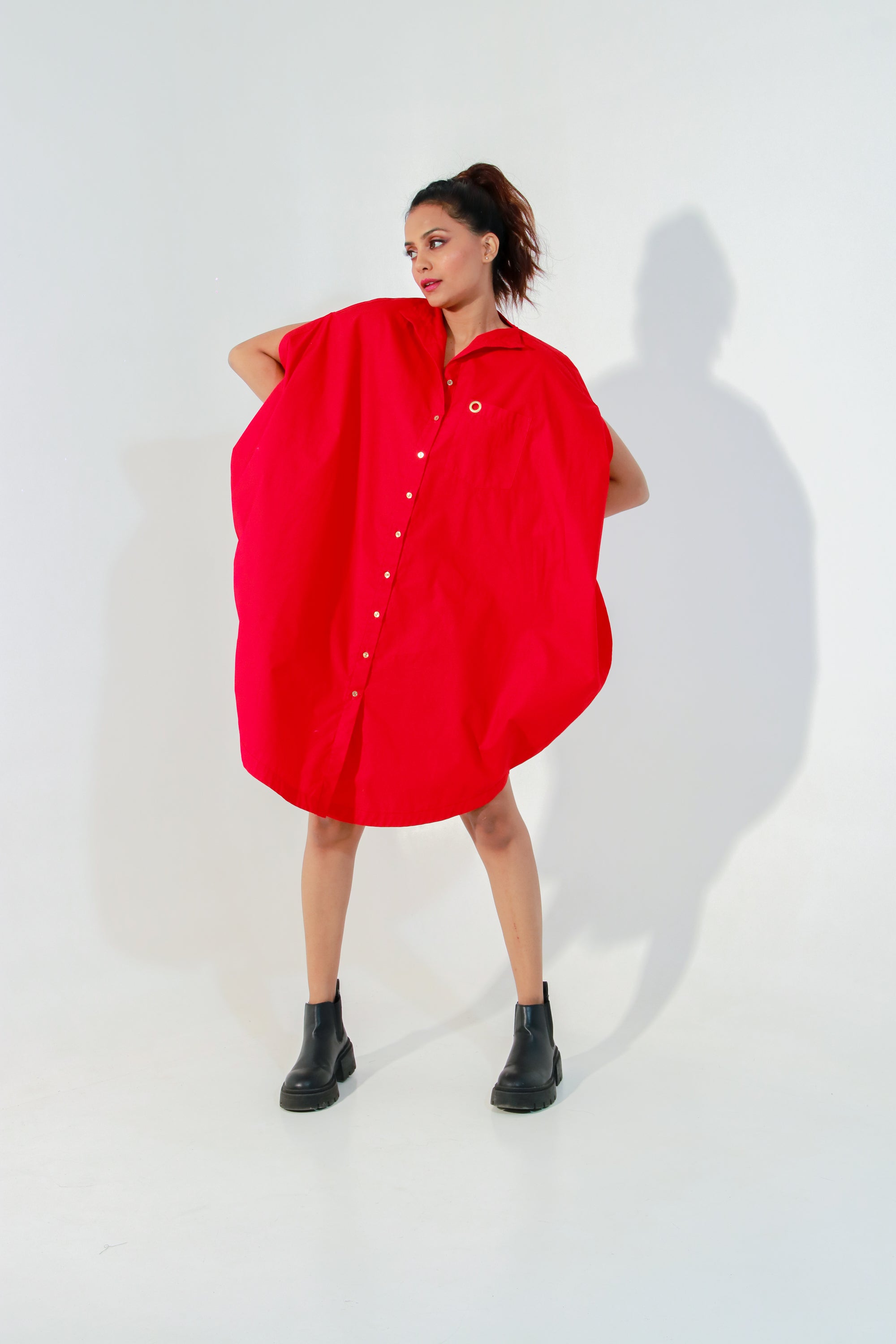 Red circle dress features one pocket & a golden eyelet.