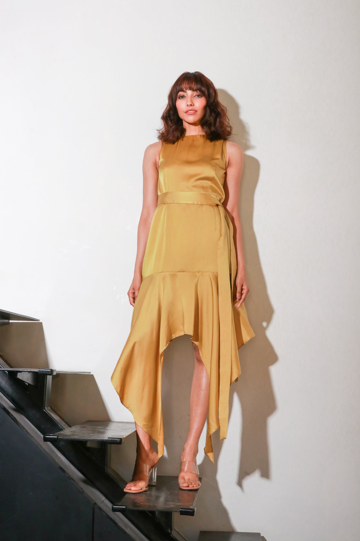 Mustard yellow fitted dress with asymmetrical bottom part.