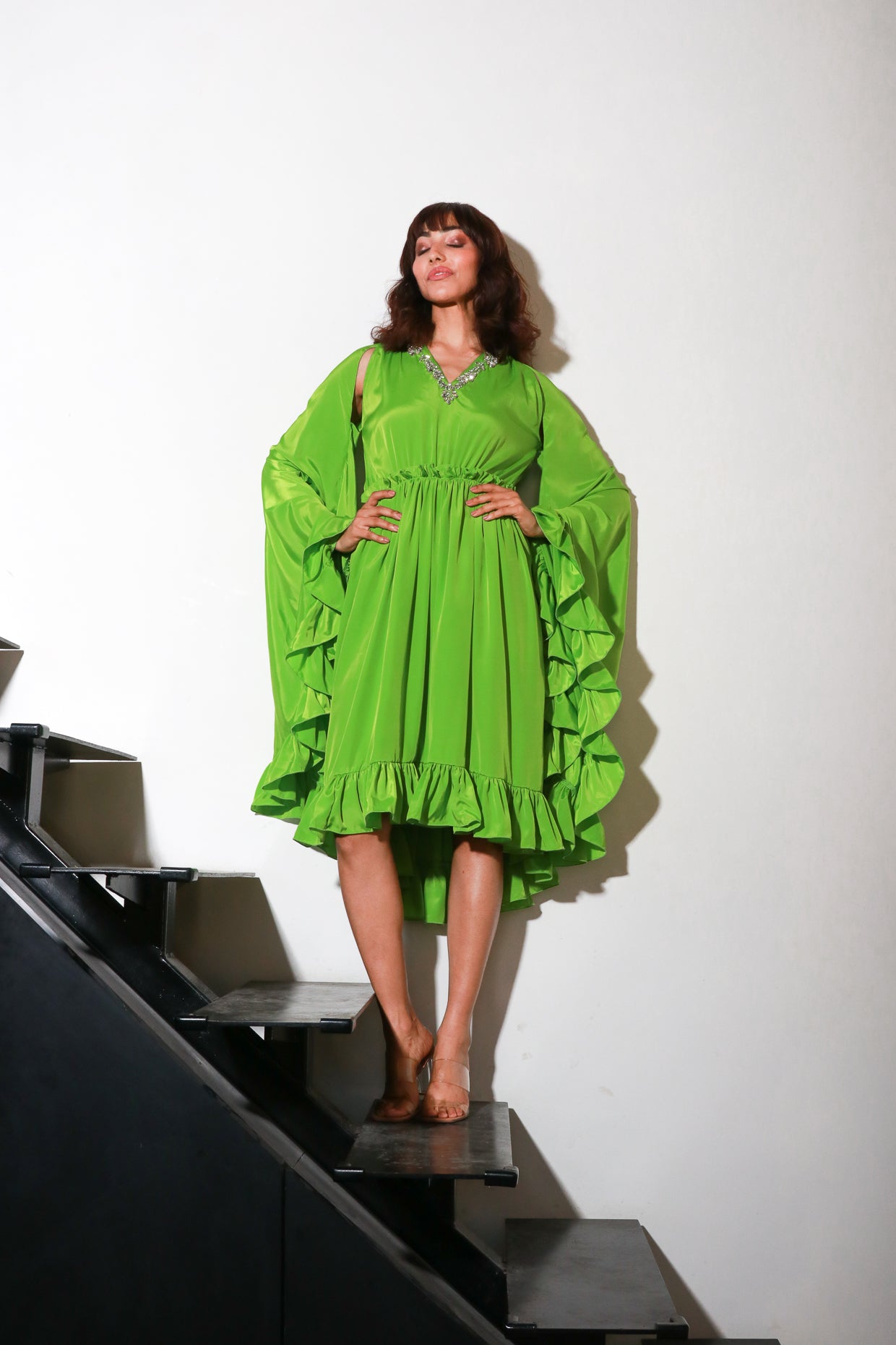 Green French crepe flared midi- dress with cape sleeves.