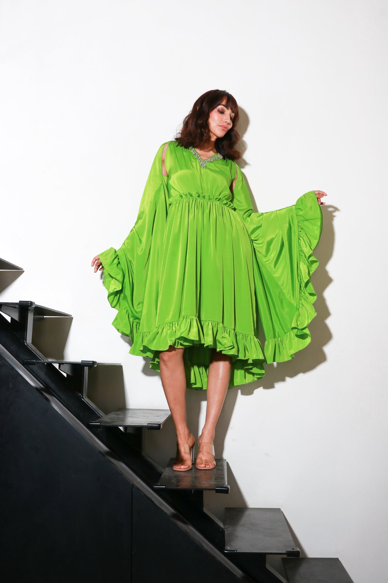Green French crepe flared midi- dress with cape sleeves.