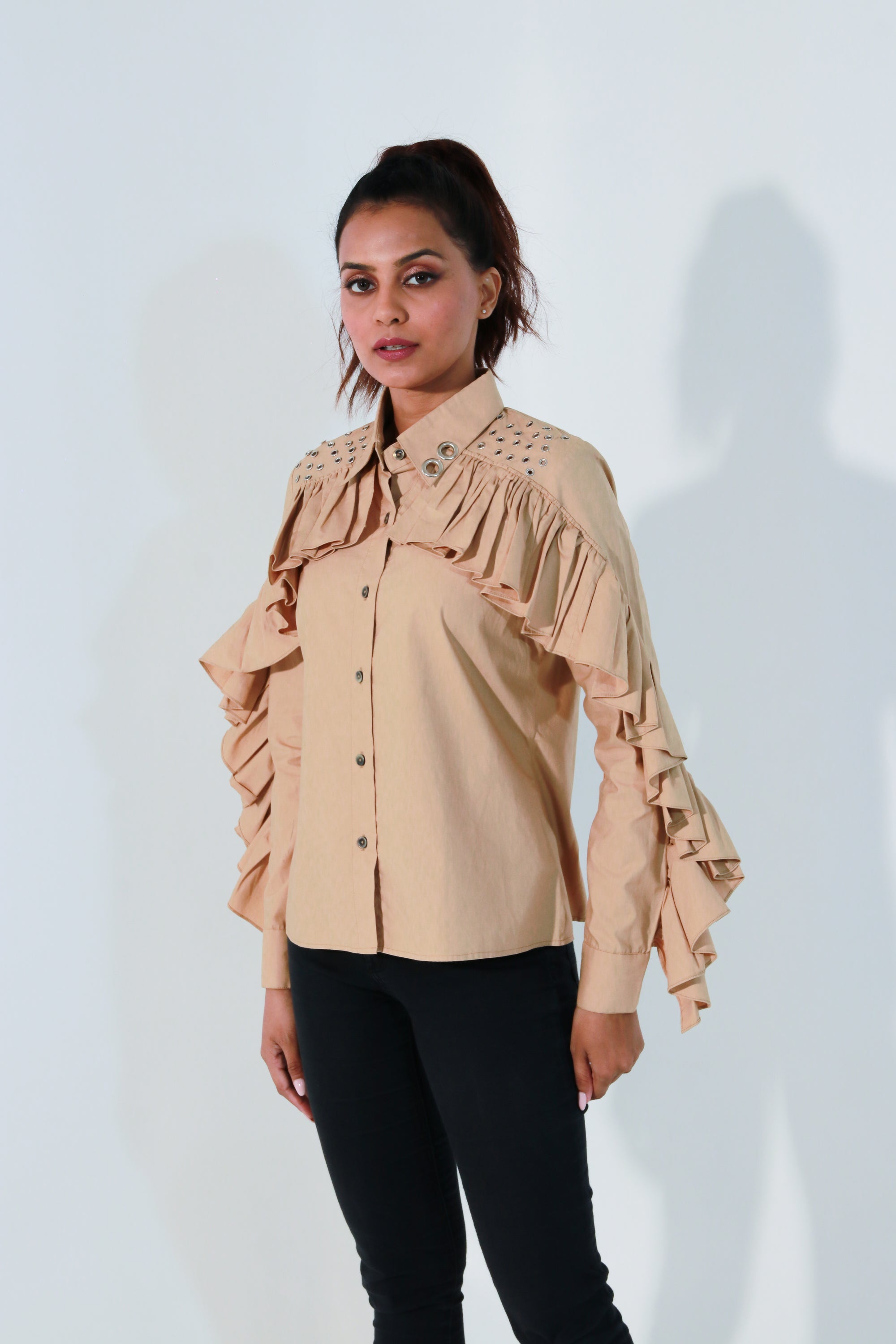 Khaki shirt features ruffles with eyelet detailing on the shoulders and collar.