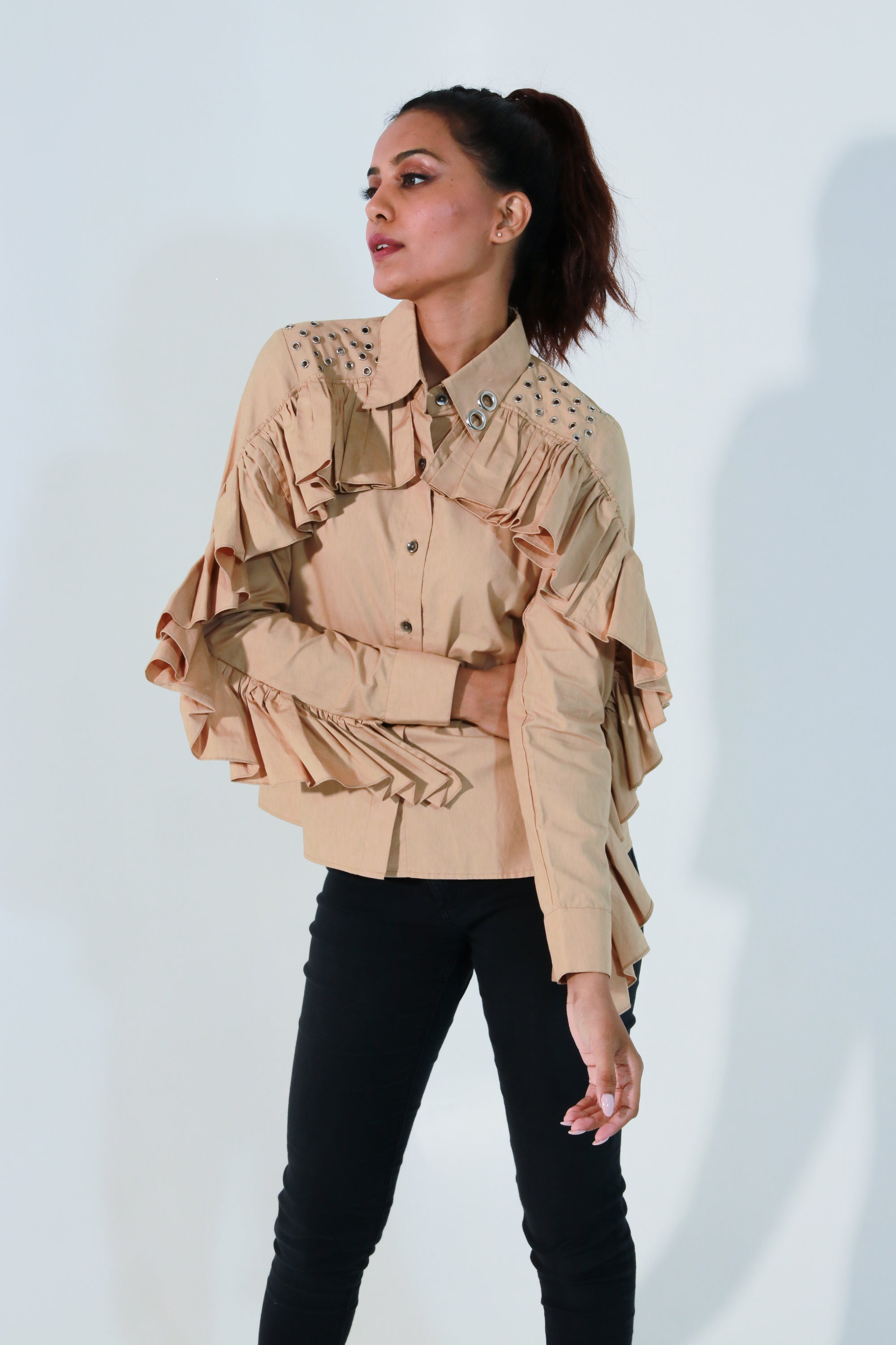 Khaki shirt features ruffles with eyelet detailing on the shoulders and collar.