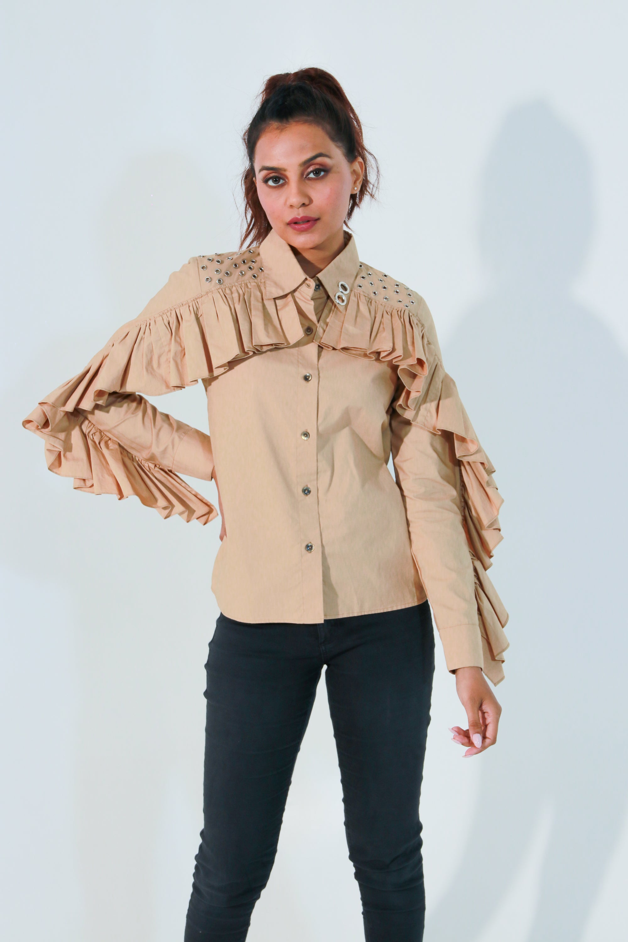 Khaki shirt features ruffles with eyelet detailing on the shoulders and collar.