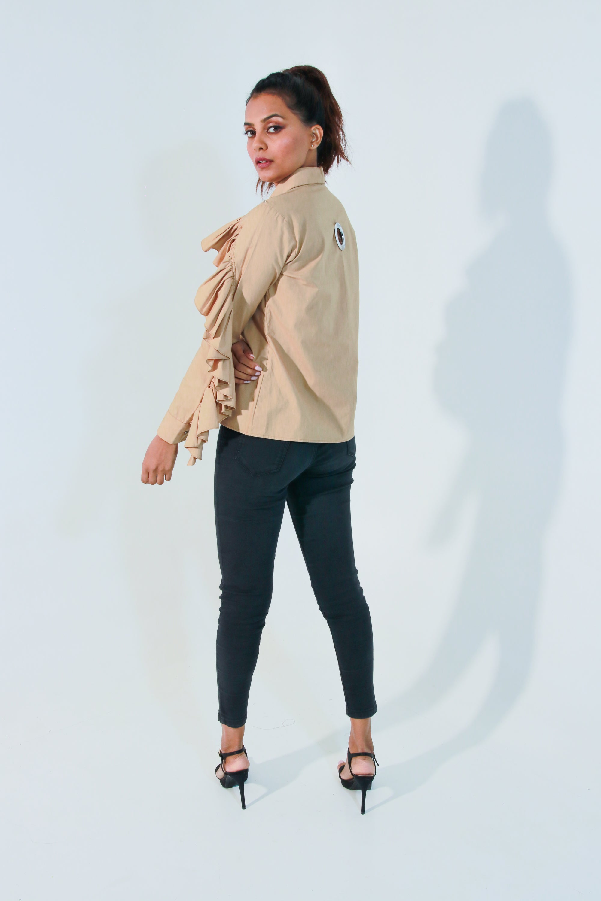 Khaki shirt features ruffles with eyelet detailing on the shoulders and collar.