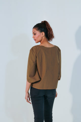 Brown top features angular slit sleeves and round neck.