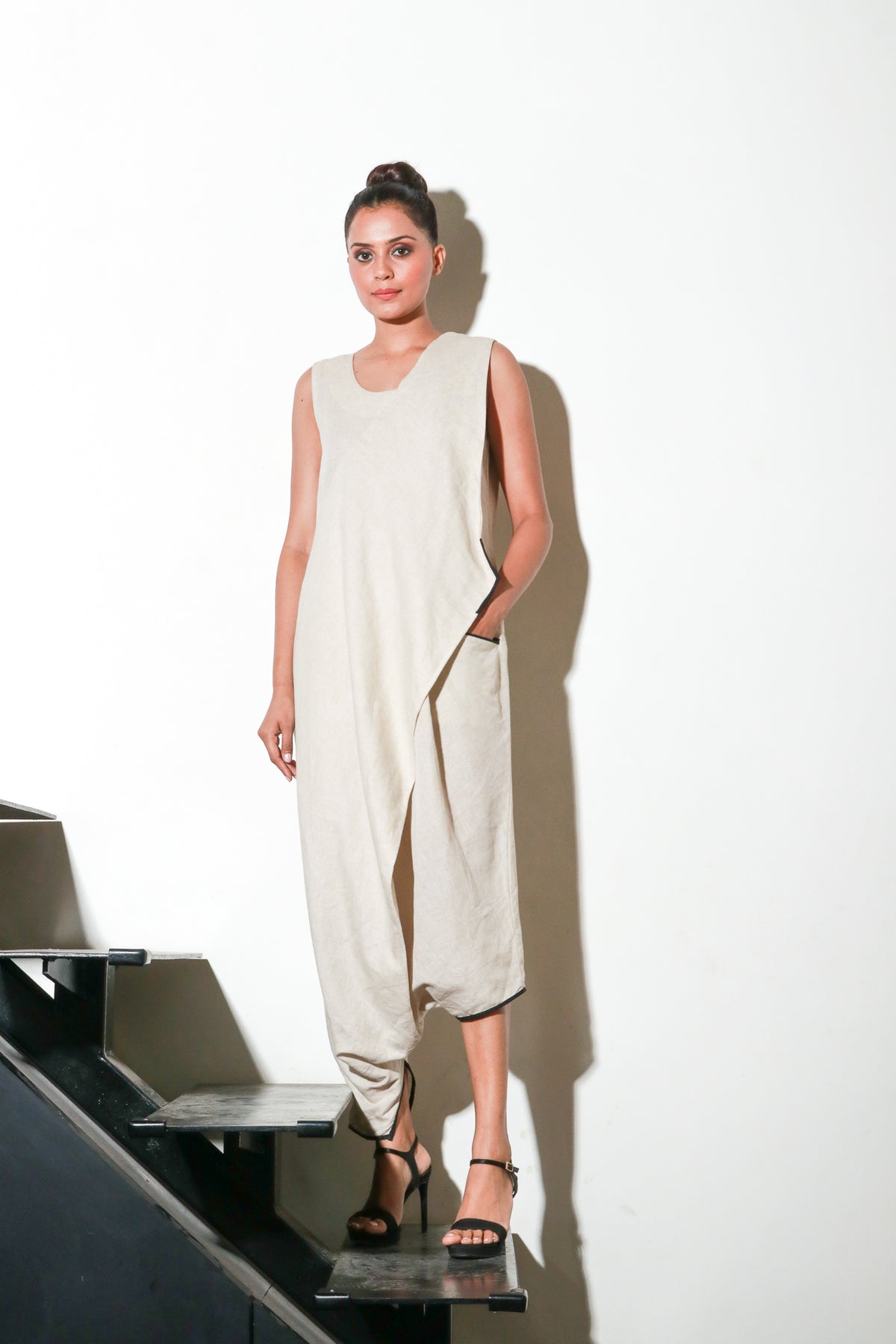 Ecru asymmetric sleeveless jumpsuits.