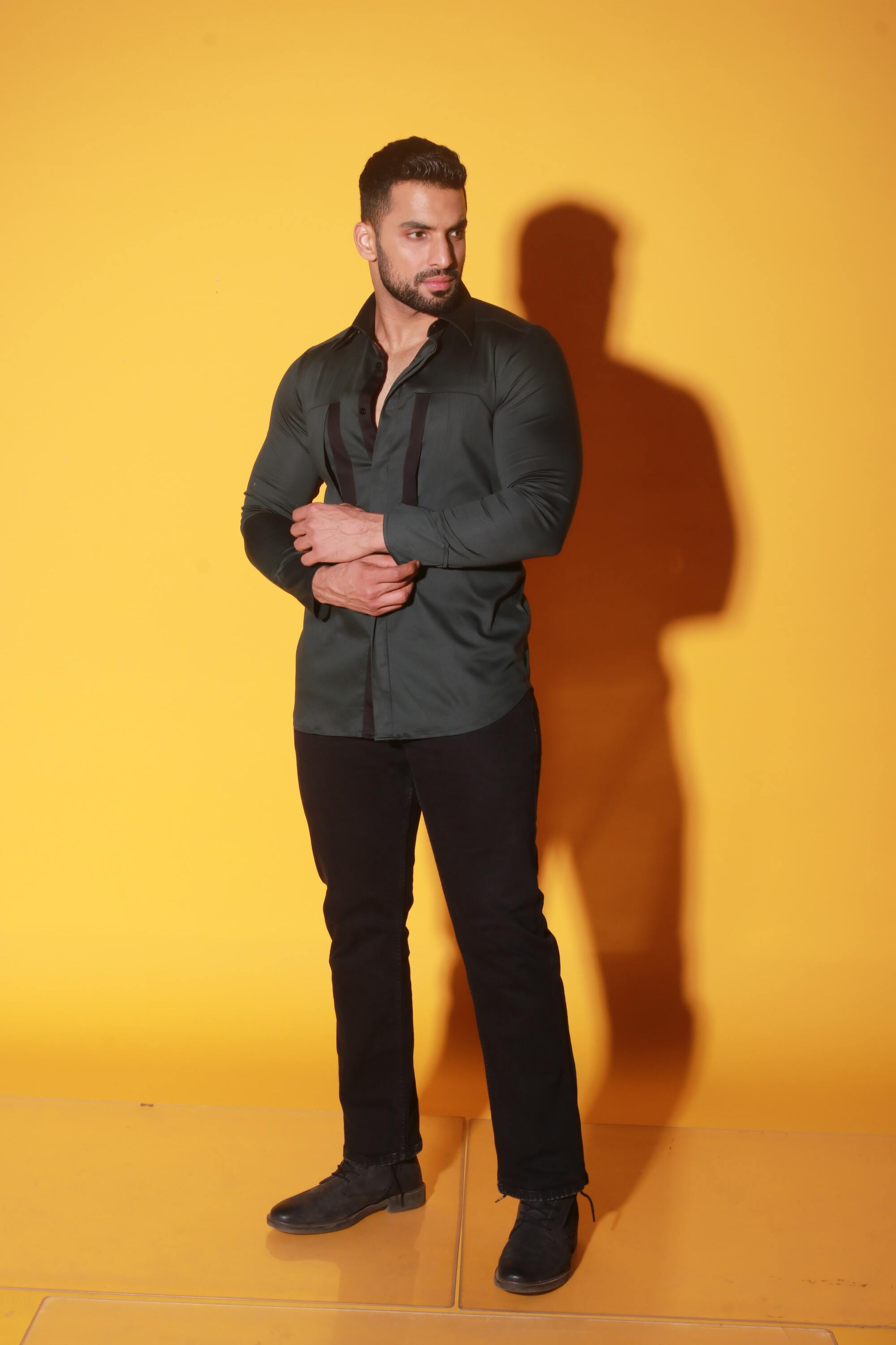 Green shirt with black detailing and diagonal pockets.