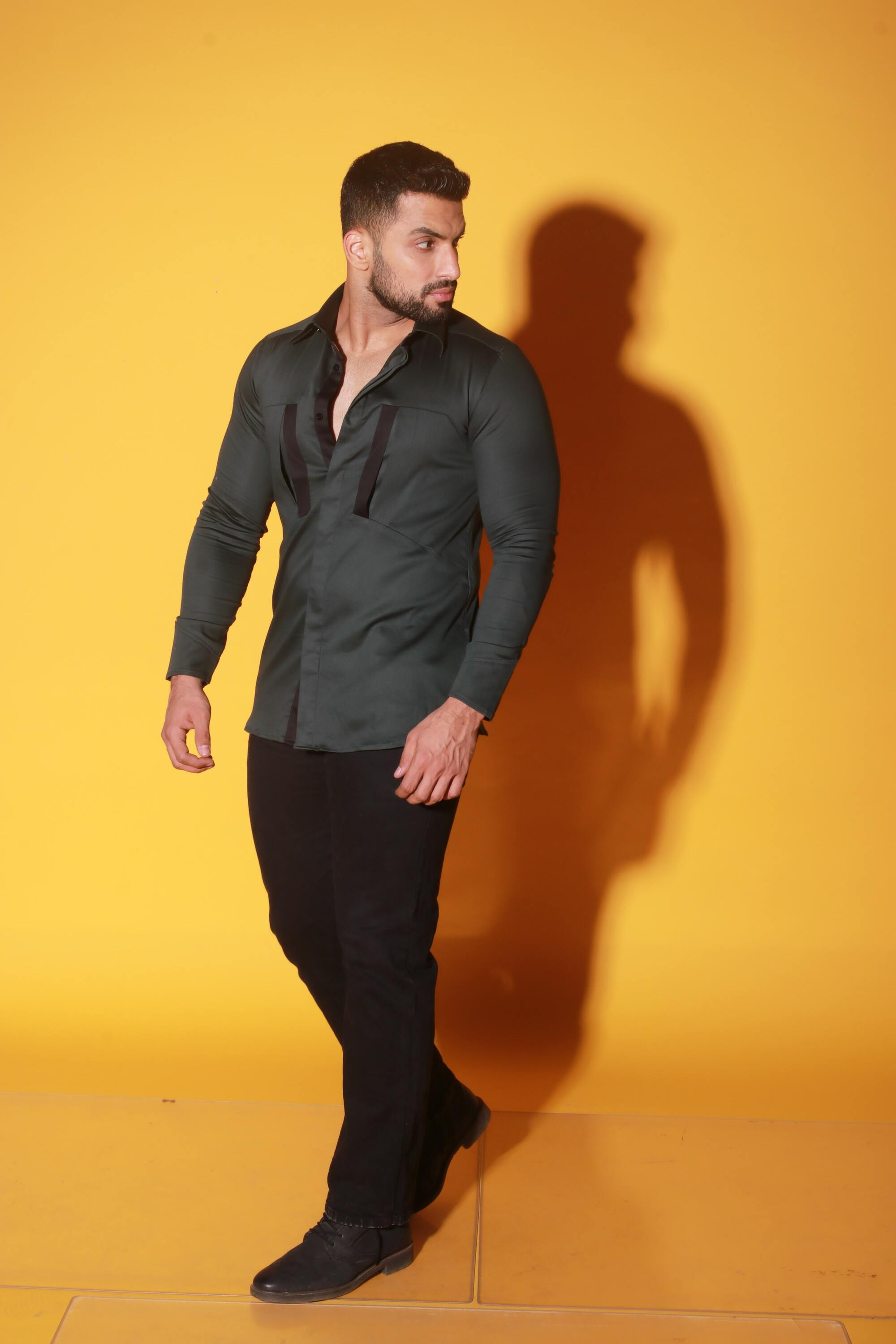 Green shirt with black detailing and diagonal pockets.