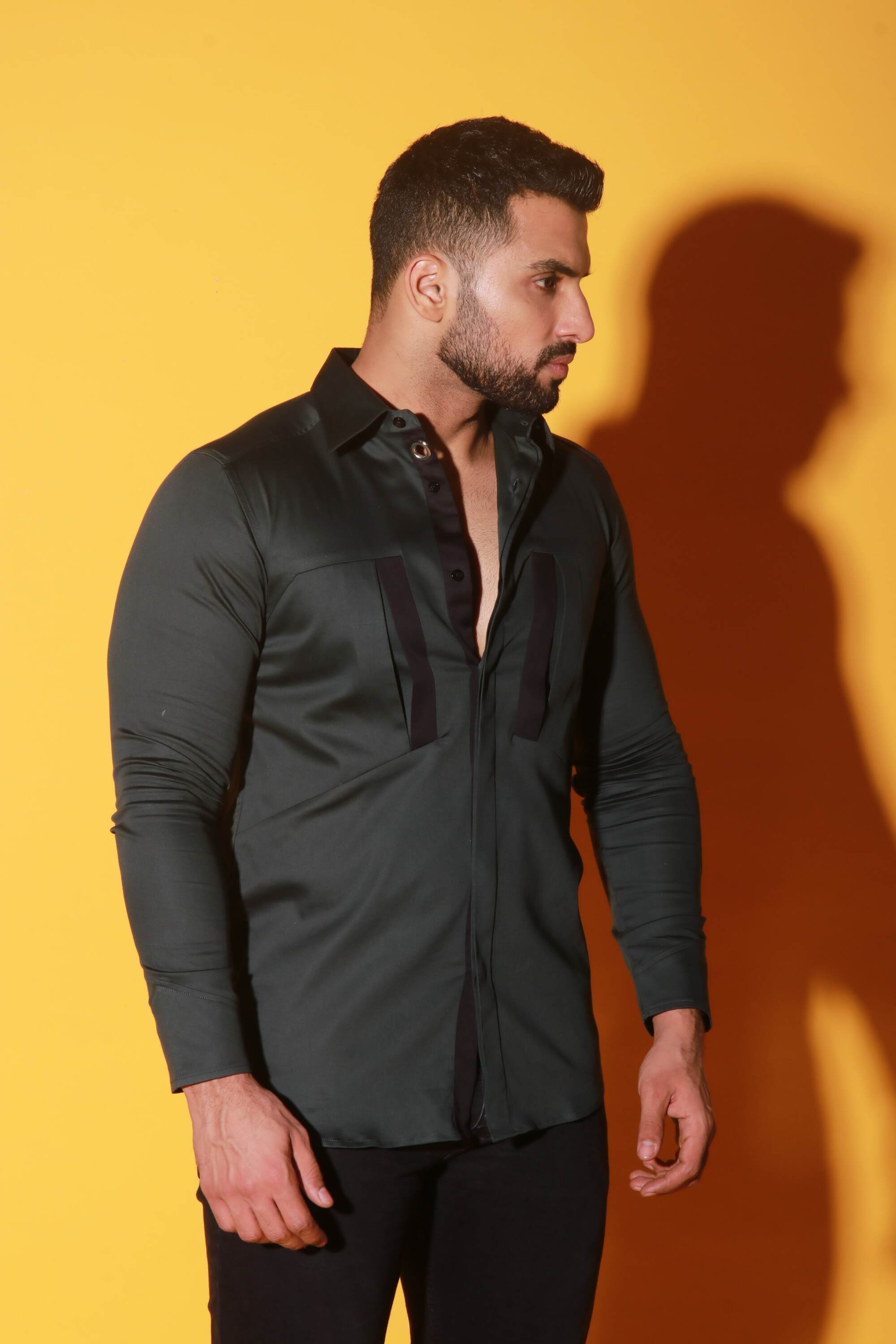 Green shirt with black detailing and diagonal pockets.