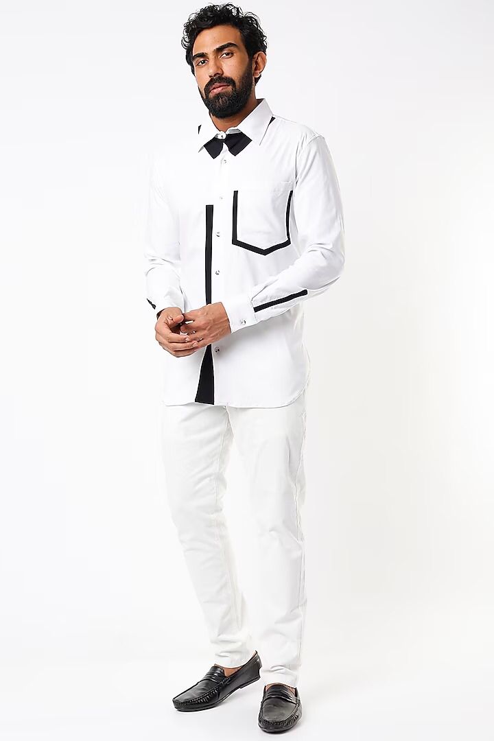 White shirt with black detailing below the collar, on placket, pocket and cuff slit