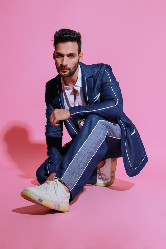 Denim jacket paired with wide legged pants with white piping detailing.