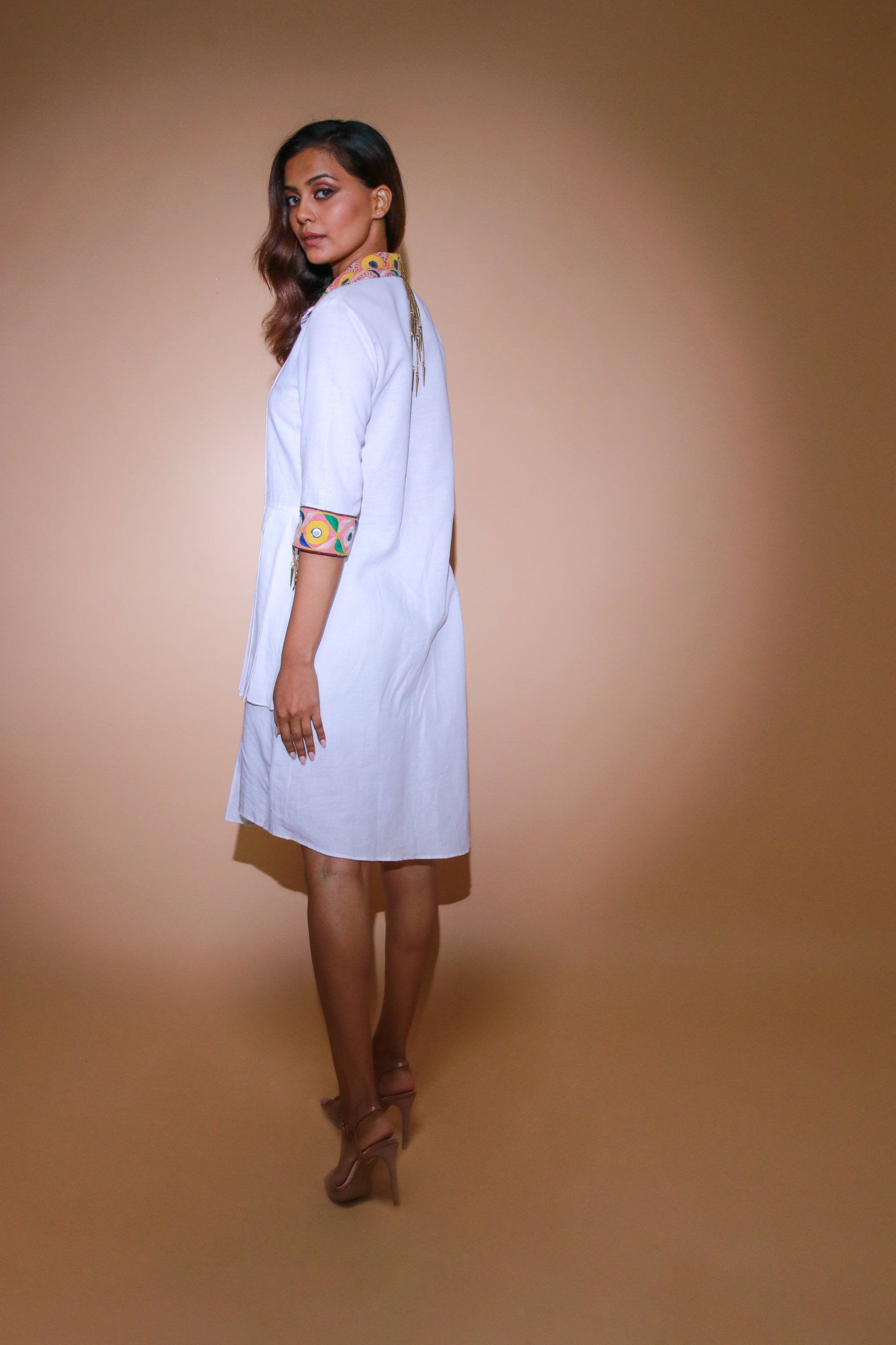 White shirt dress features a pleated yoke with Kutch border on collar and cuffs.