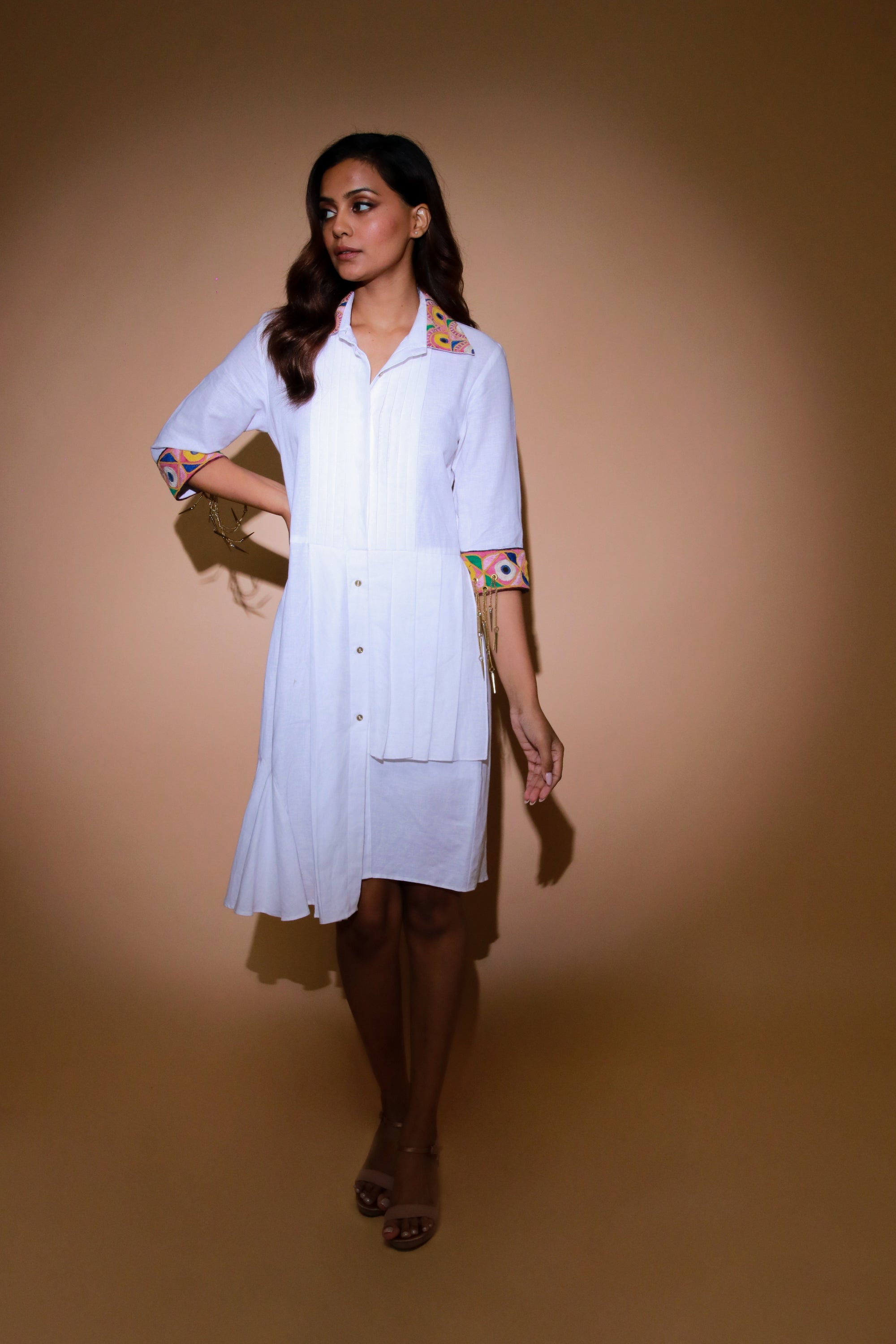 White shirt dress features a pleated yoke with Kutch border on collar and cuffs.