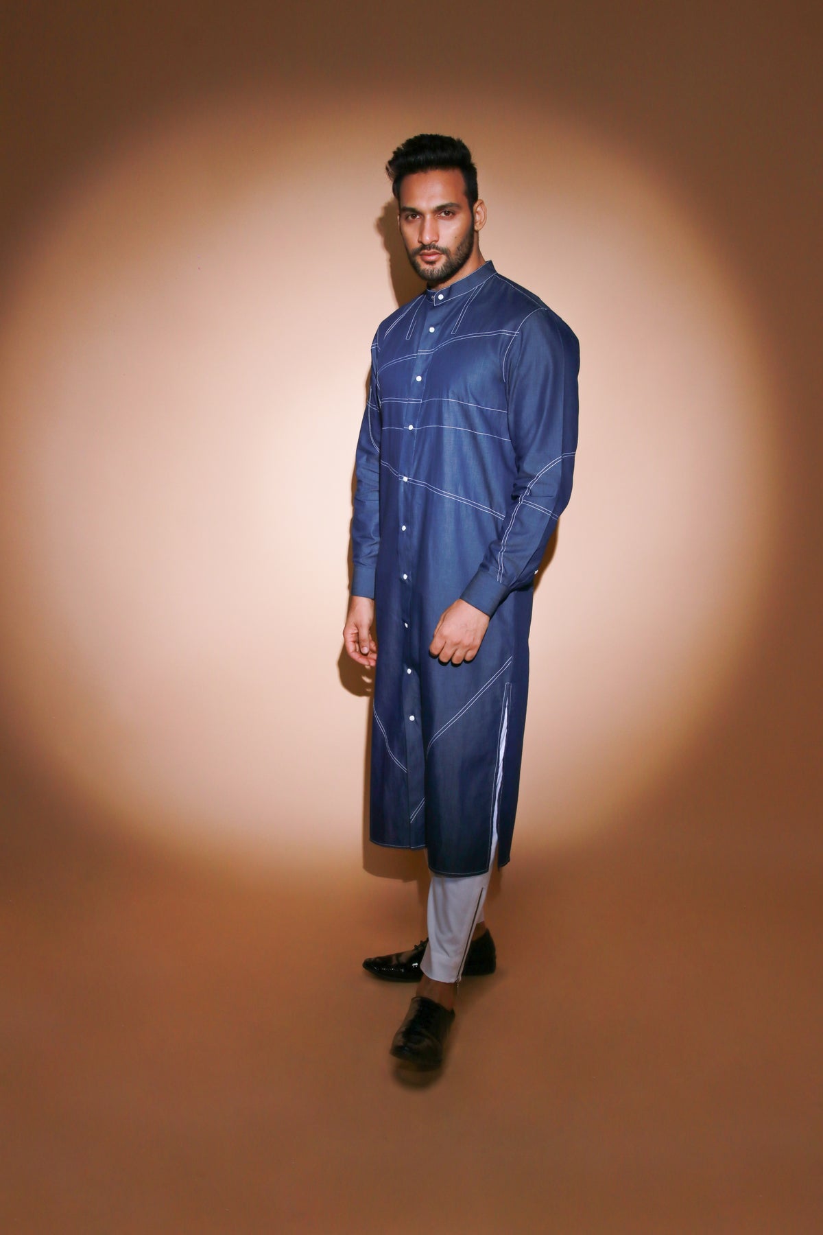 Denim long kurta with contrast stitch detailing and narrow white pants .