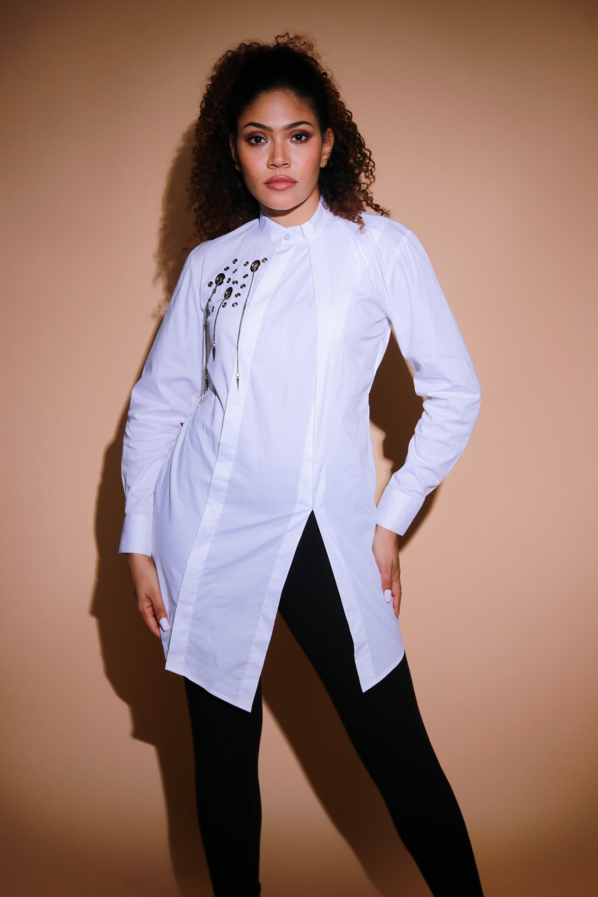 White top features an open side flap and eyelet and chains embellishment.