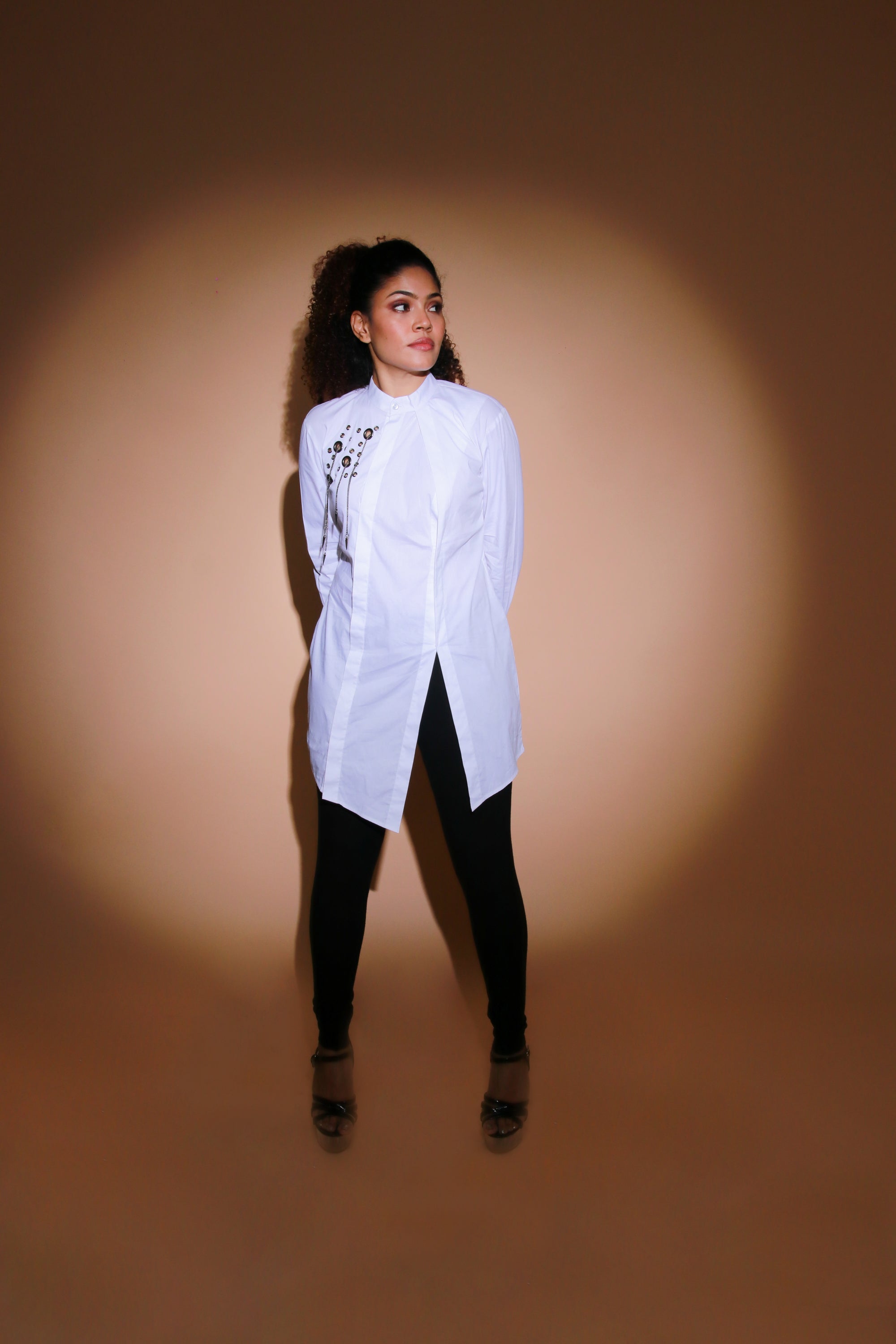 White top features an open side flap and eyelet and chains embellishment.