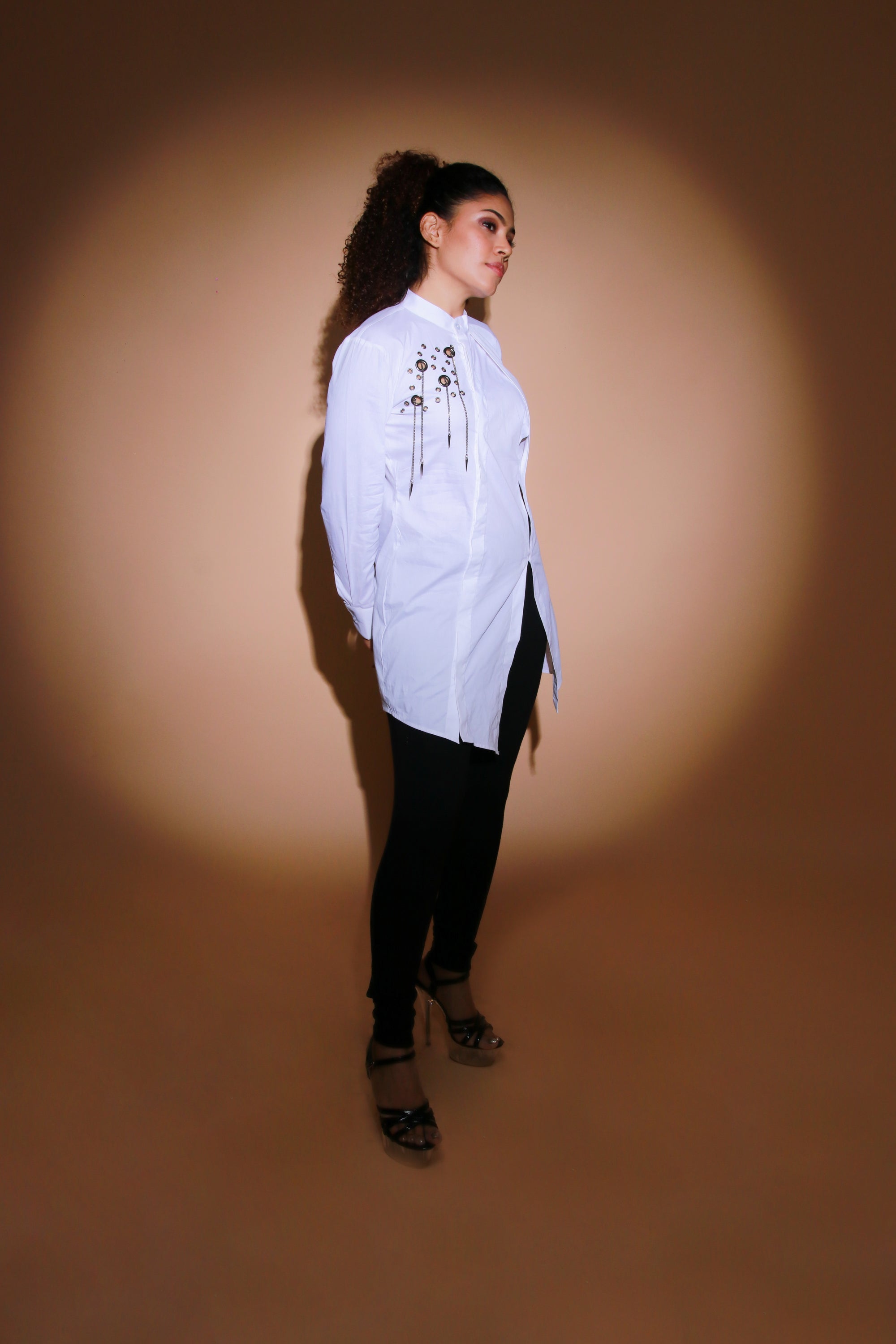 White top features an open side flap and eyelet and chains embellishment.