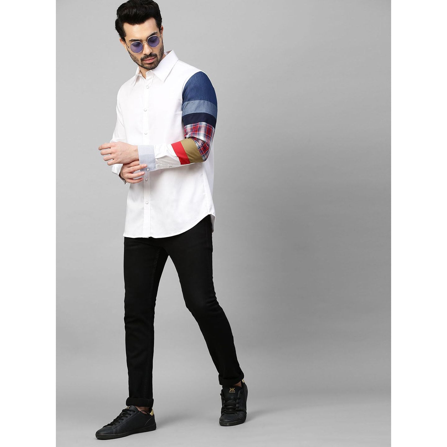 White shirt with patch detailing on one sleeve.