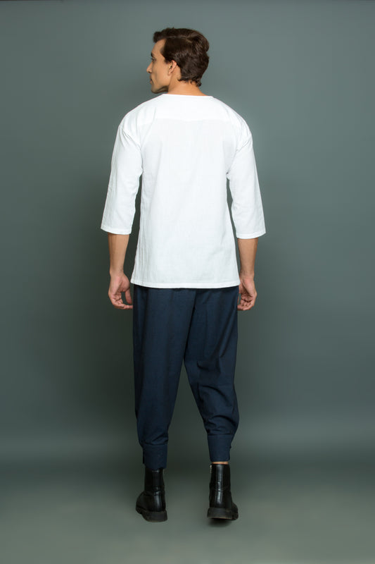 White asymmetric round neck top with cuff pants.