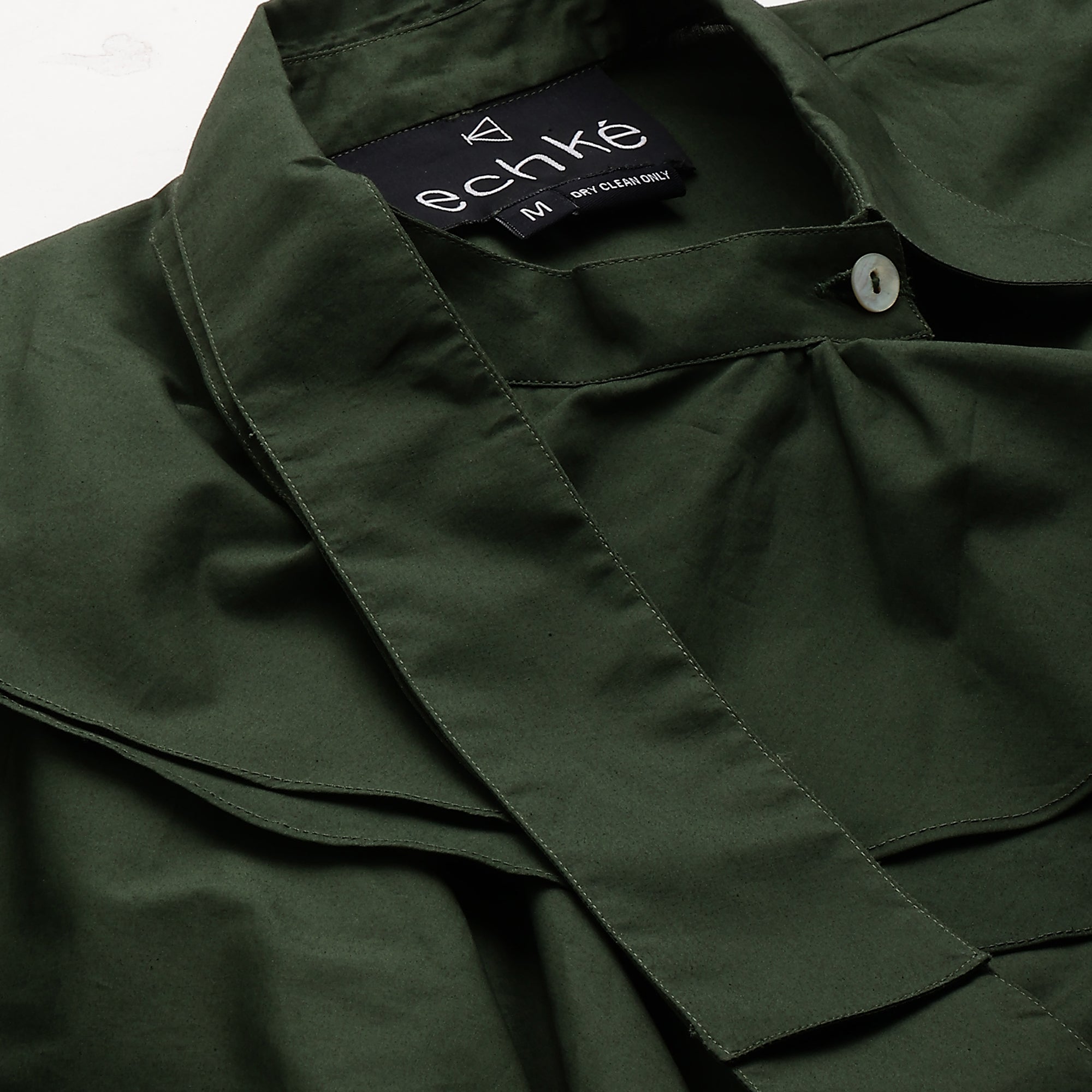 Military green sleeveless shirt features an extended collar and frill detailing.