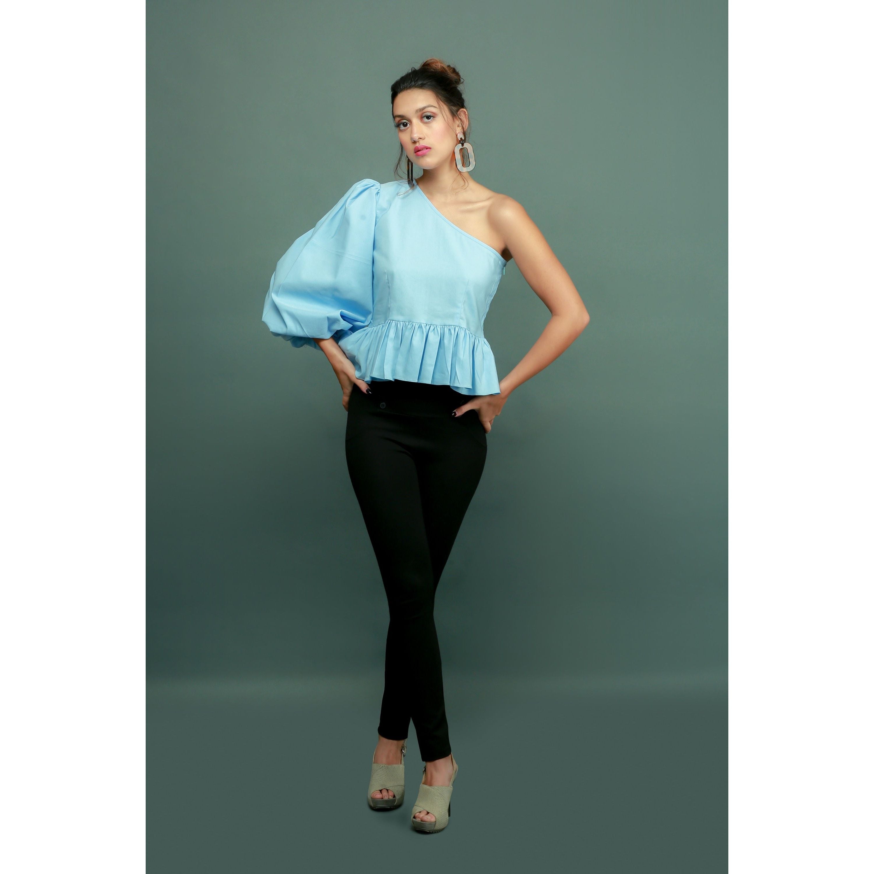 Light blue one-shoulder top features a peplum waist and balloon sleeves.