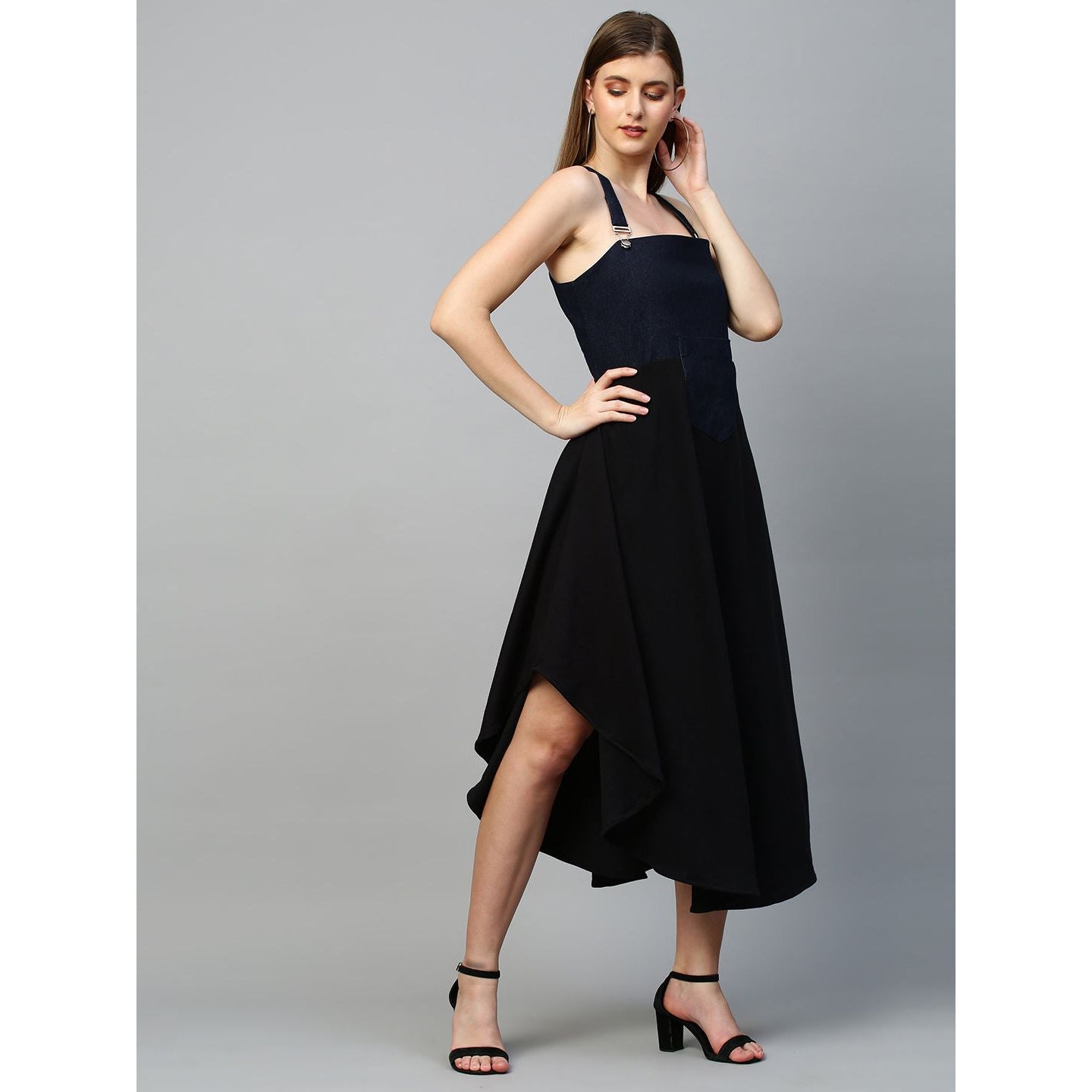 Denim dungaree dress features an assymmetric hemline.