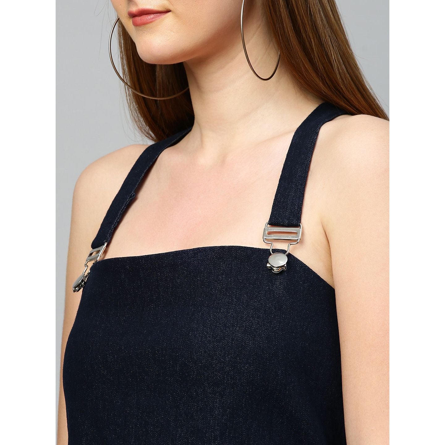 Denim dungaree dress features an assymmetric hemline.