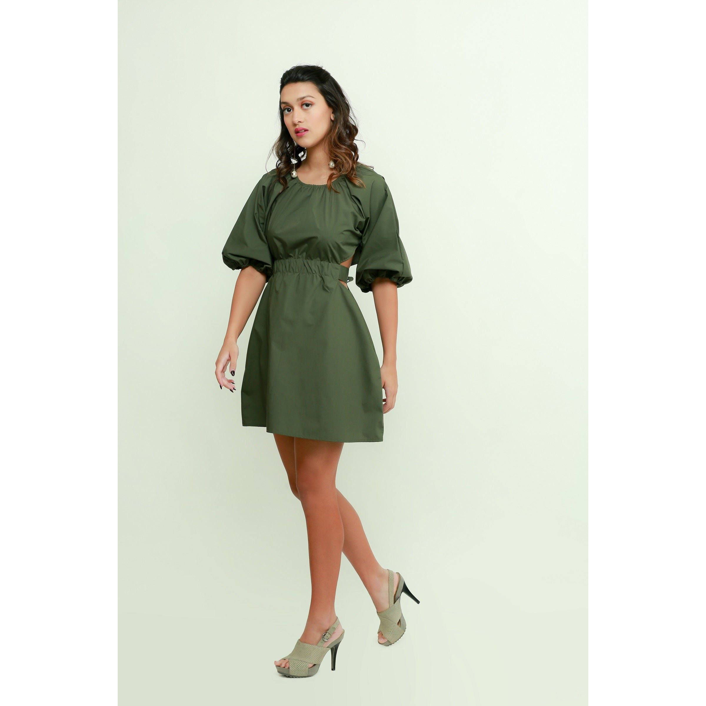 Military green short dress features an elasticated center, side mid-riff opening and a back tie-up.