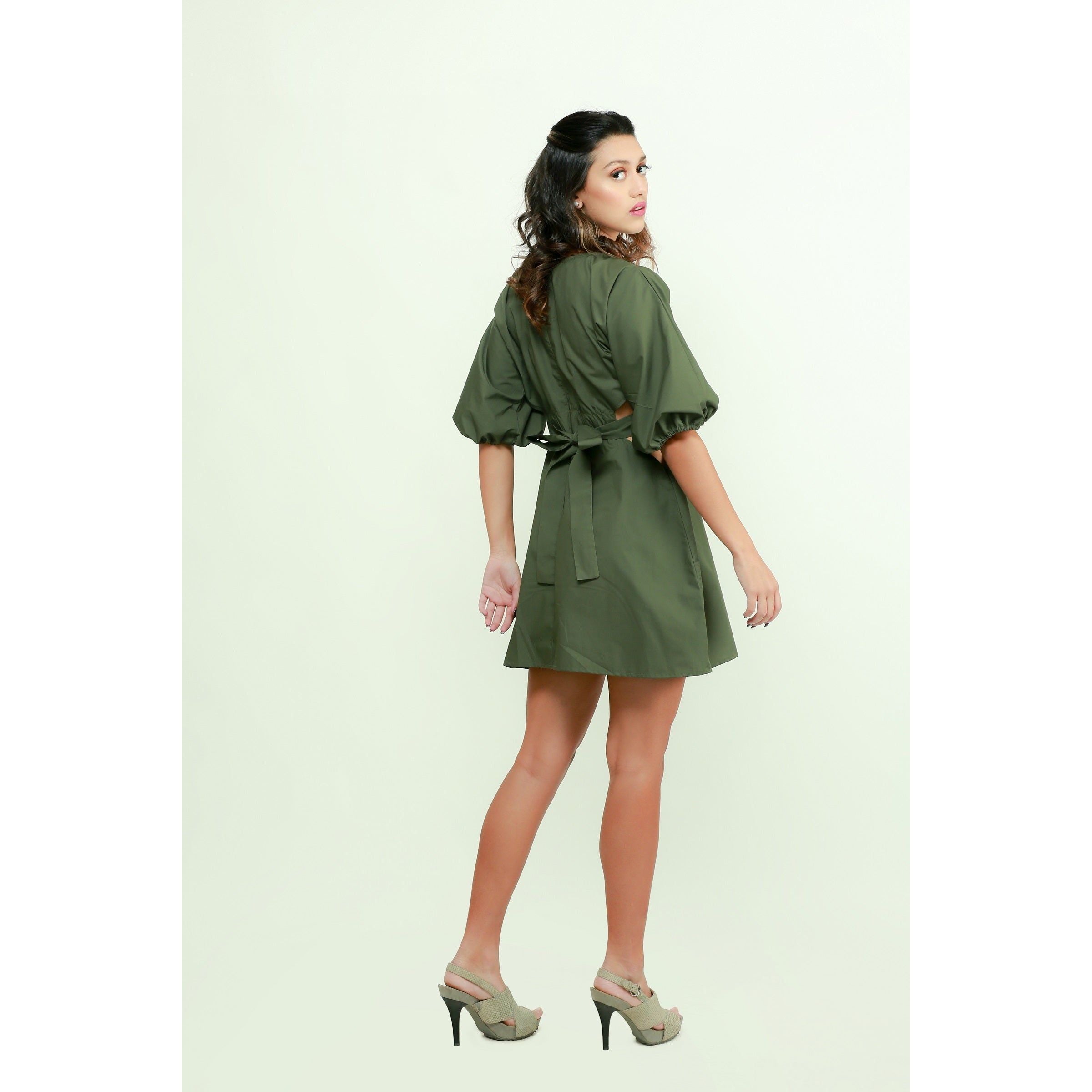 Military green short dress features an elasticated center, side mid-riff opening and a back tie-up.